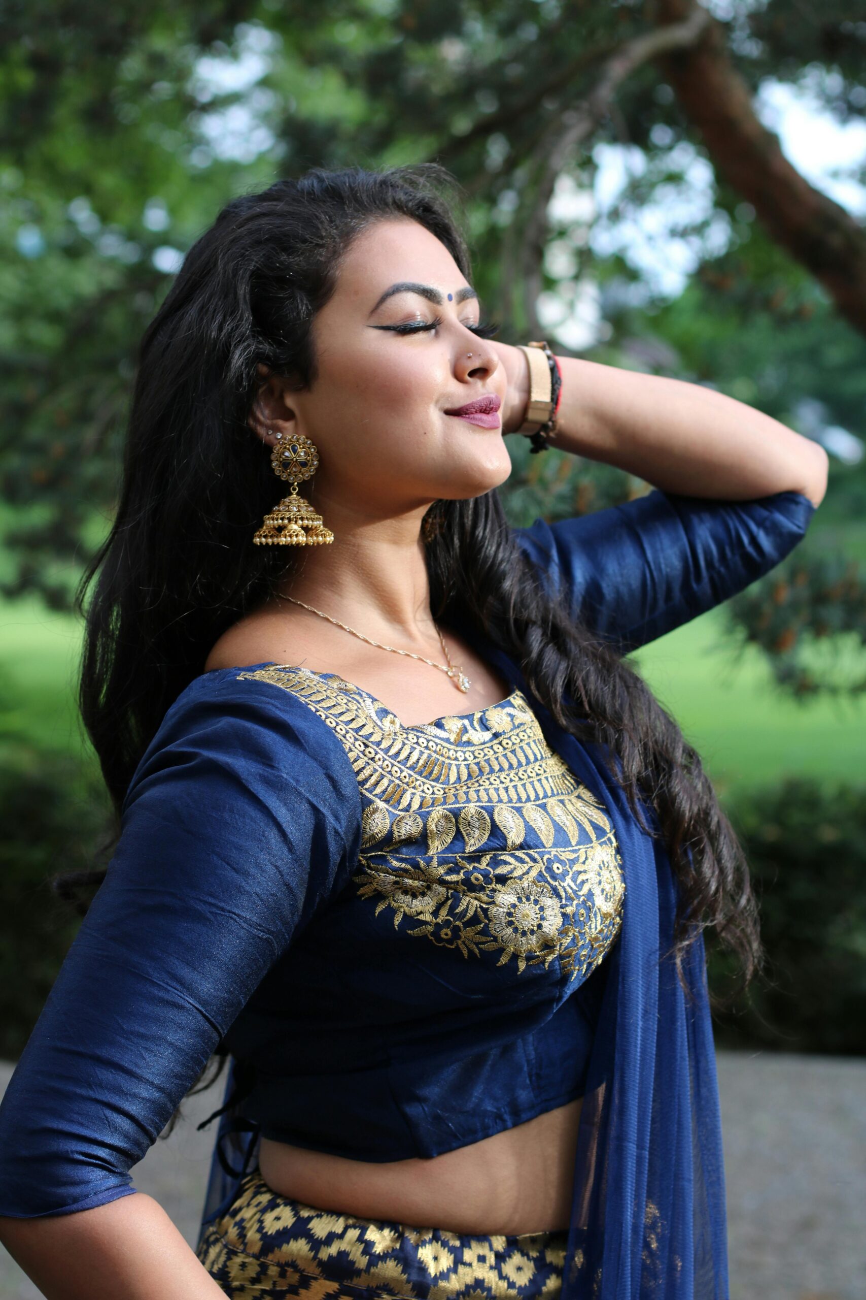 Testimonial Portrait of a woman in traditional blue and gold attire, posing outdoors.