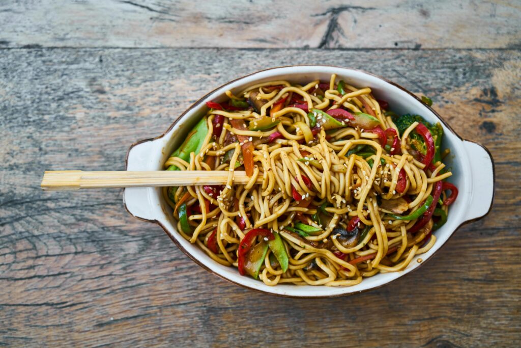 Home Tasty stir-fried noodles with fresh vegetables and sesame seeds, perfect for a healthy meal.