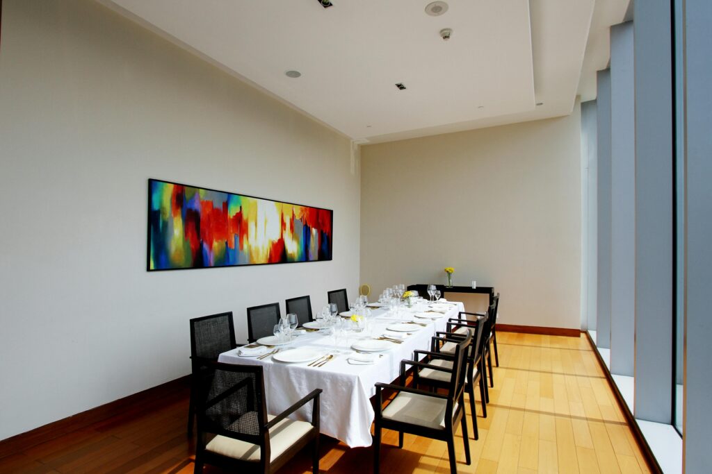 Bright dining room with modern art, set for a formal event. Minimalist and sophisticated design.